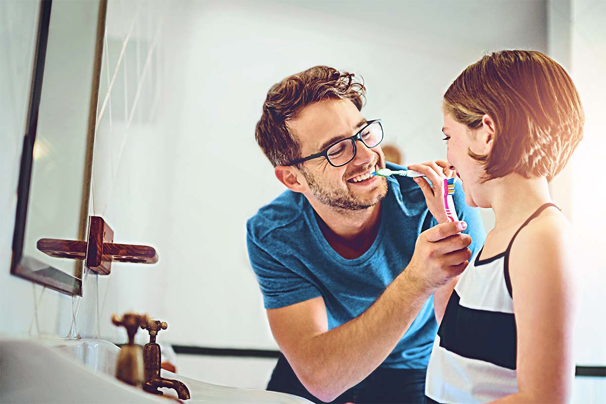 two people performing preventative dental care including flossing and brushing